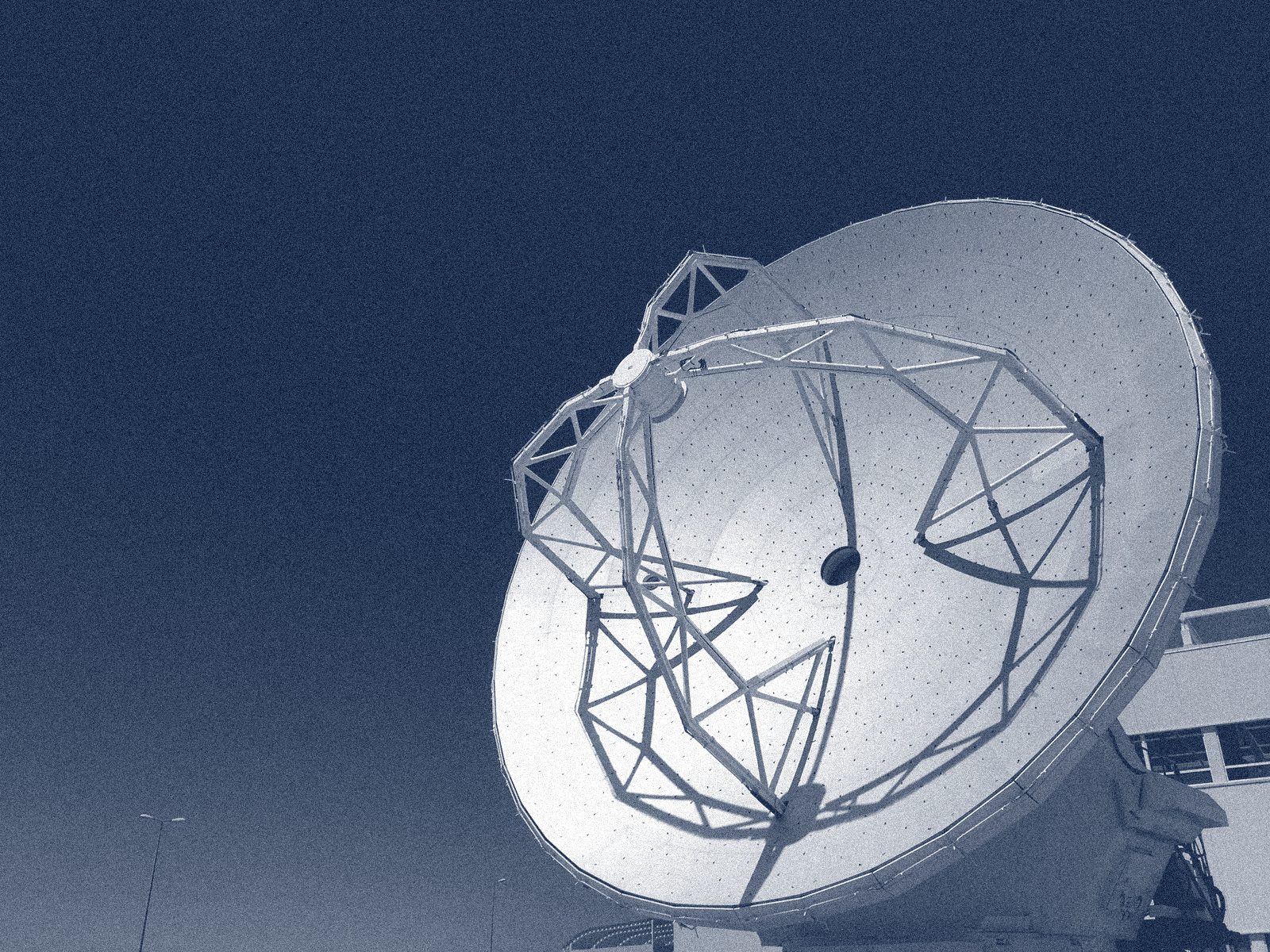 An ALMA radio telescope dish against a deep blue sky, Atacama, Chile.