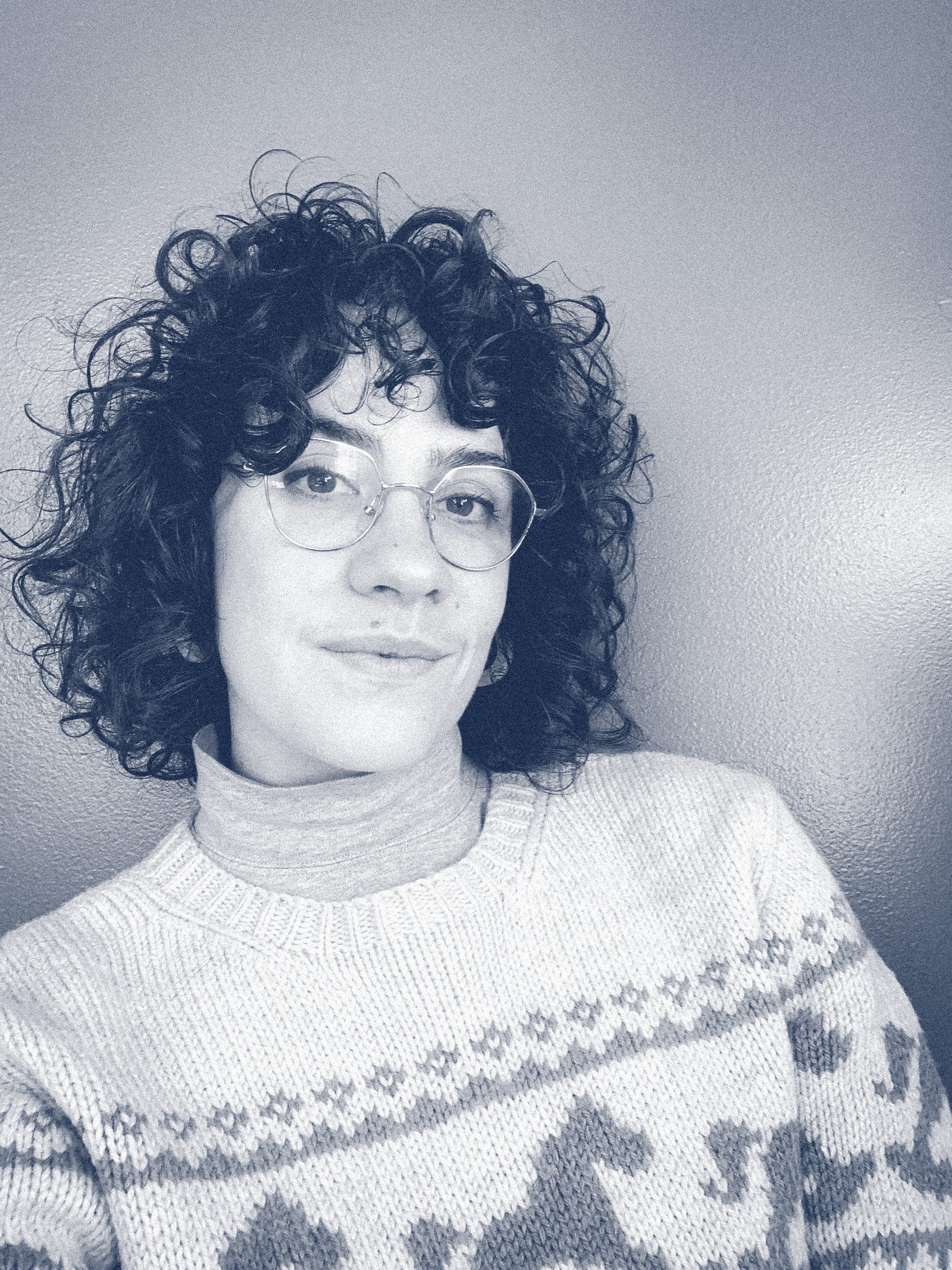 Portrait of Raquel Velho, smiling, seated in her living room.